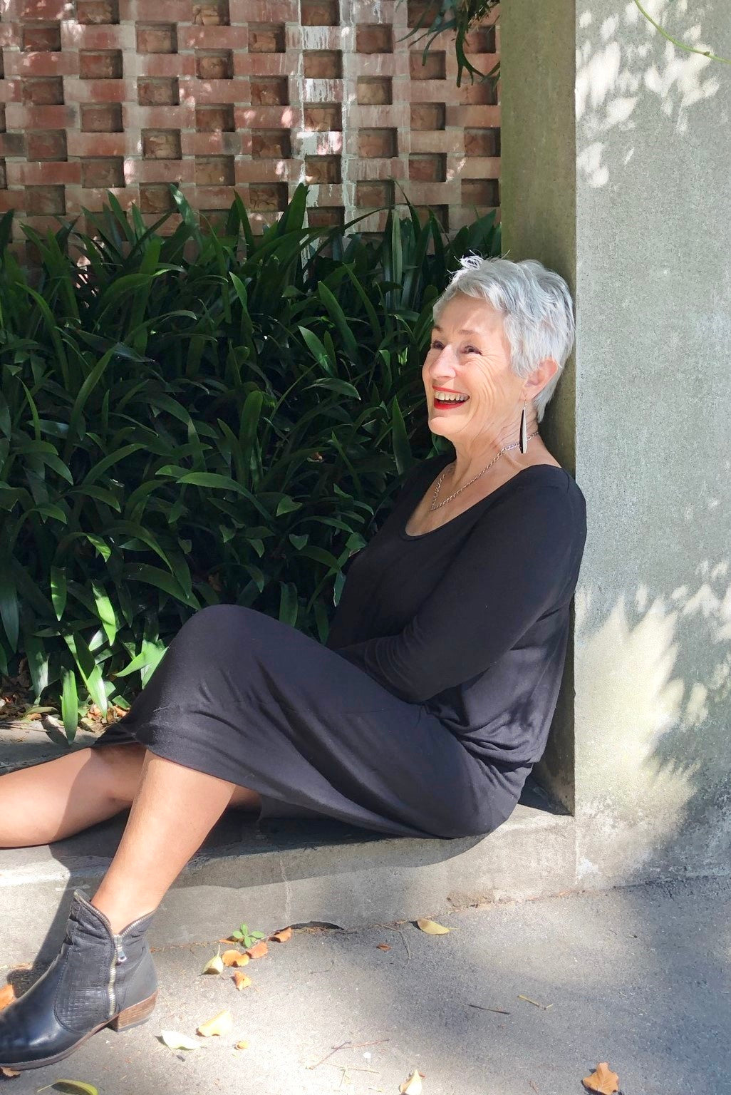 Pīwakawaka Fantails recycled plastic earrings worn on an older woman, Made in NZ